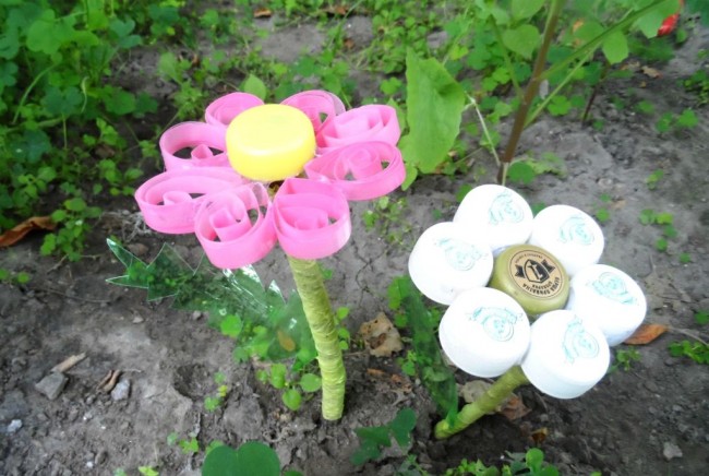 Занаяти от тапи от пластмасови бутилки. Пластмасови ярки цветя за градината могат да бъдат направени чрез техниката на квилинг (изрязване на основните ленти от венчелистчета от бутилките) или както е посочено в стъпка по стъпка ръководството по-долу