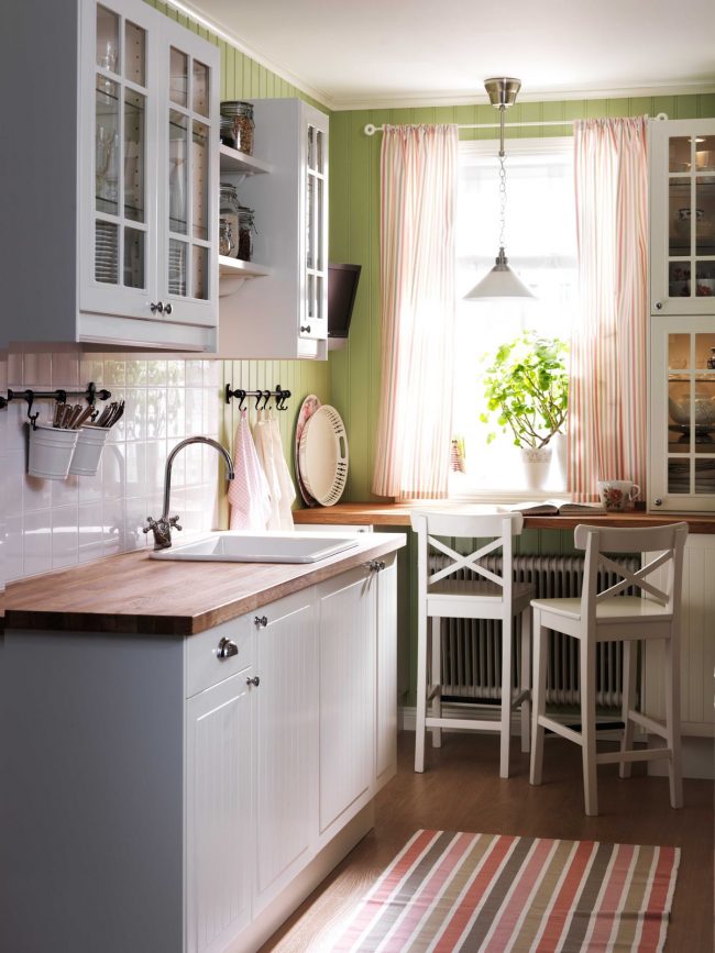 За да спестите място в малка кухня, можете да подредите перваза на прозореца като трапезария.