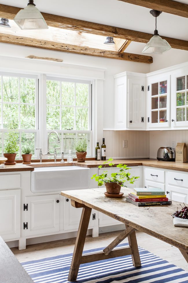 Лека кухня с ярки акценти върху дървени мебелни елементи. Забележете как перваза на плота плавно влиза в кухненския комплект