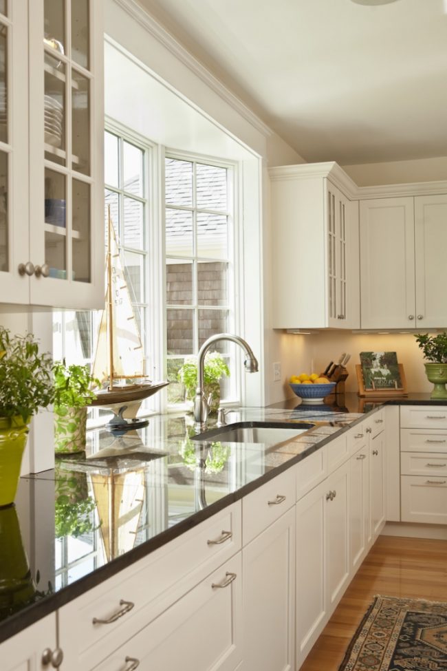 Кухнята на частна къща с нестандартна стърчаща дограма, която ви позволява да увеличите площта на работната повърхност на перваза на прозореца