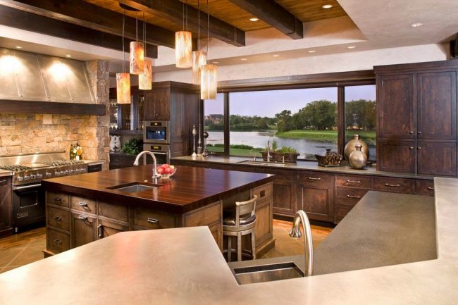 Луксозна кухня с дървена кухненска част и панорамен прозорец на цялата стена, украсена с перваза на плота