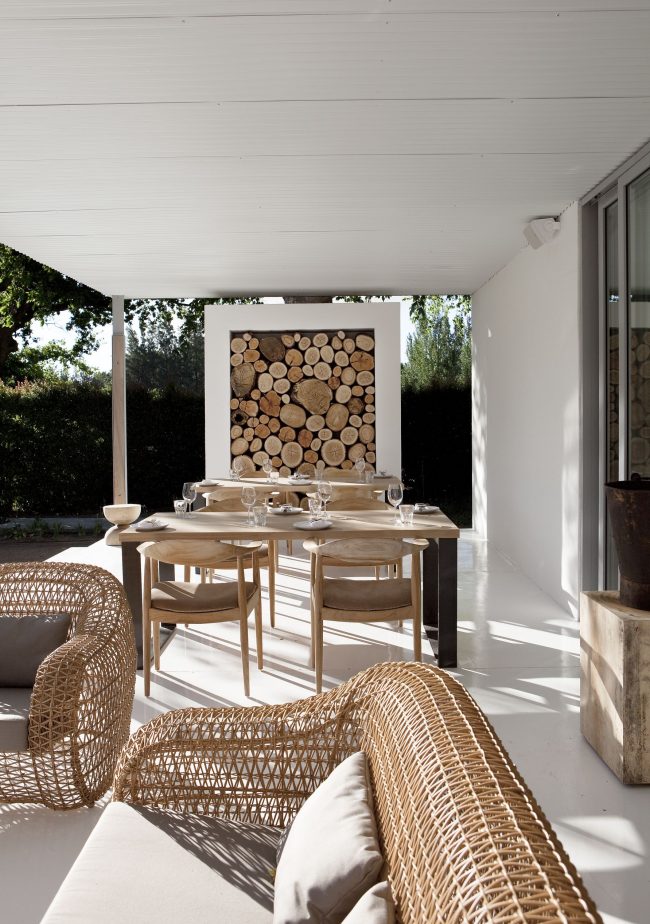 Ein Holzstapel mit darin gestapeltem Brennholz kann zum Mittelpunkt des Sommerbereichs im Innenhof eines Privathauses werden