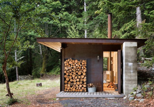 Eine kleine Sommerküche auf dem Territorium des Innenhofs eines Privathauses mit einem ausgewiesenen Platz unter einem Schuppen für einen Holzstapel für Brennholz
