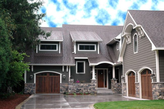 Цветни каменни основи, стенни дървени сайдинги, керемидени покриви са завършването на традиционен американски дом с гаражи. Характеристика: поставяне на гаражи