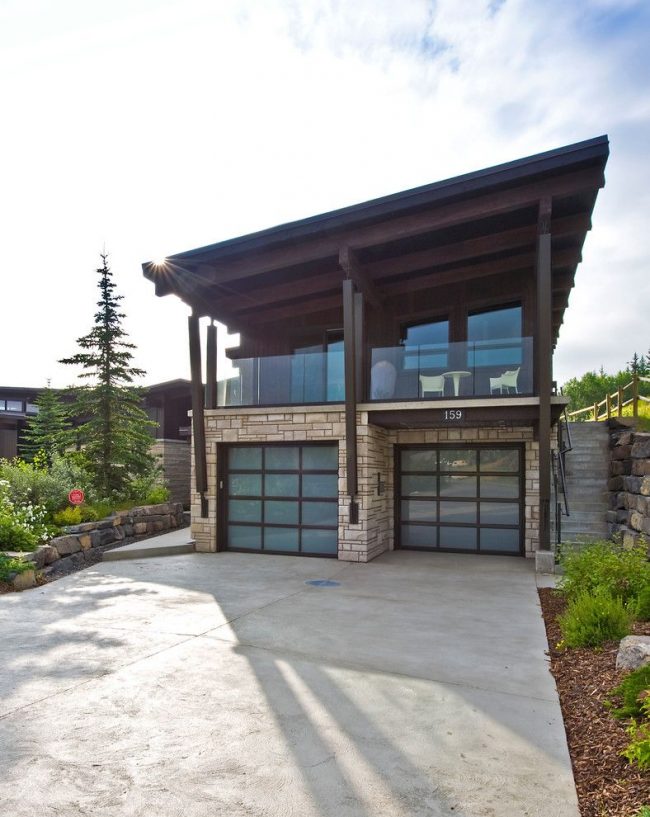 Индивидуален проект на модерна двуетажна къща с два гаража. Характеристика на първия етаж на къща с гаражи в шахматно разположение. Втори етаж - скатен покрив