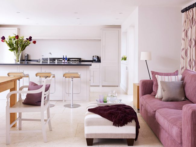 أرائك مستقيمة قابلة للطي لكل يوم: أريكة قابلة للطي باللون الوردي الرماد في داخل المطبخ الأبيض