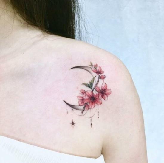 tatuaż na ramieniu z kwiatem wiśni z półksiężycem