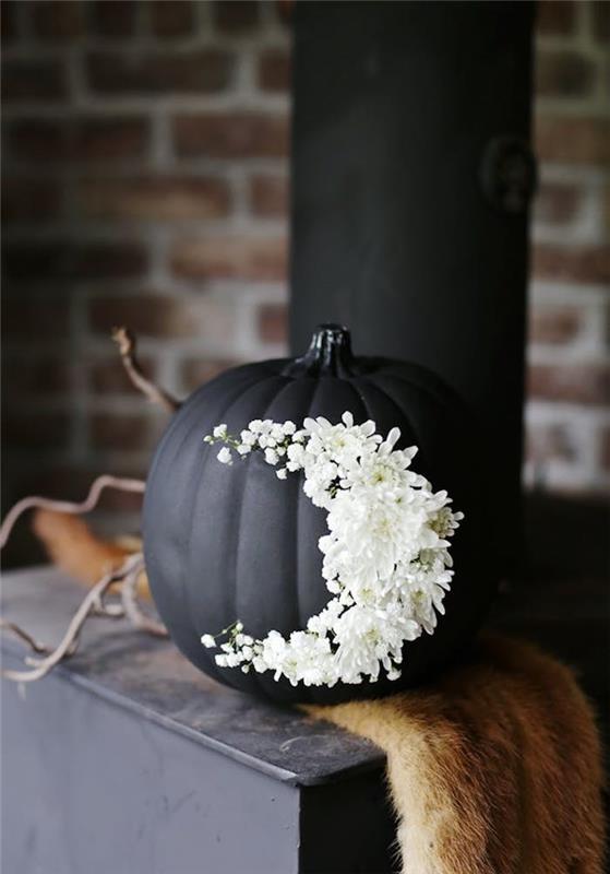 citrouille noire avec des fleurs blanches pour décorer halloween