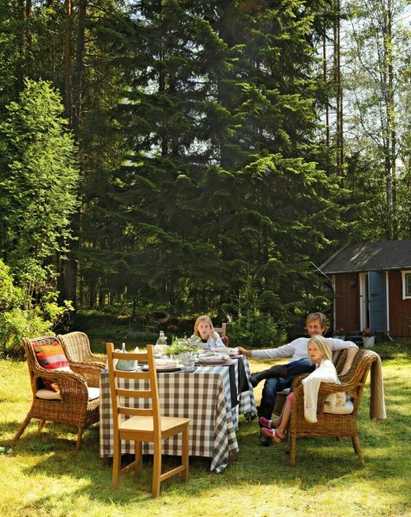 Abri de jardin suédois fauteuils en rotin et nappe à carreaux