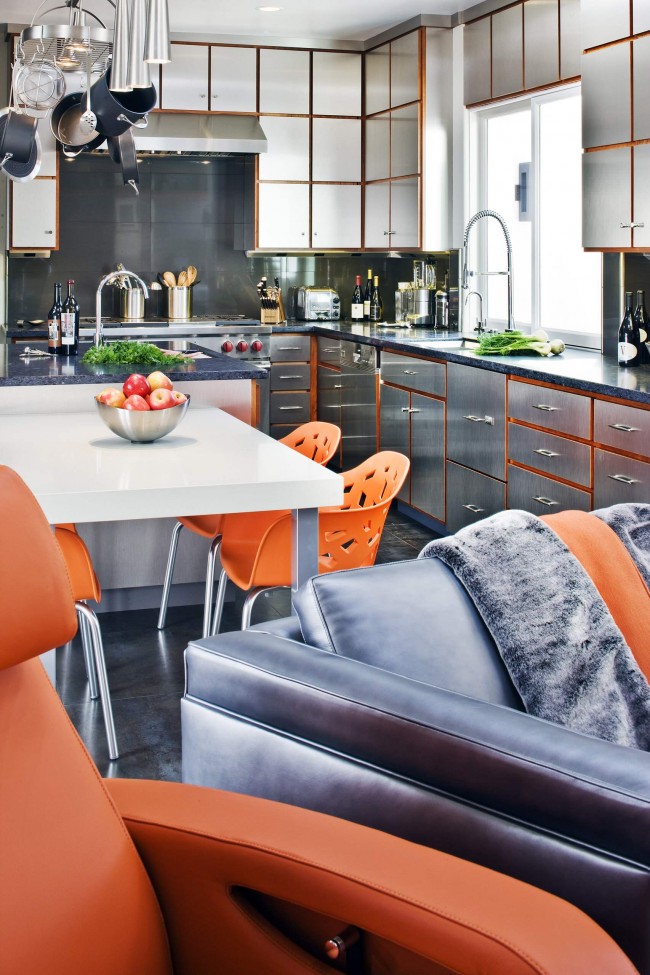 Orange Farbe vereint den Raum dieser Wohnung: Es ist auch auf den Oberflächen von Schränken, in einem Farbton von lackiertem Holz, und in der Polsterung von Polstermöbeln und hellen Designer-Kunststoffstühlen präsent