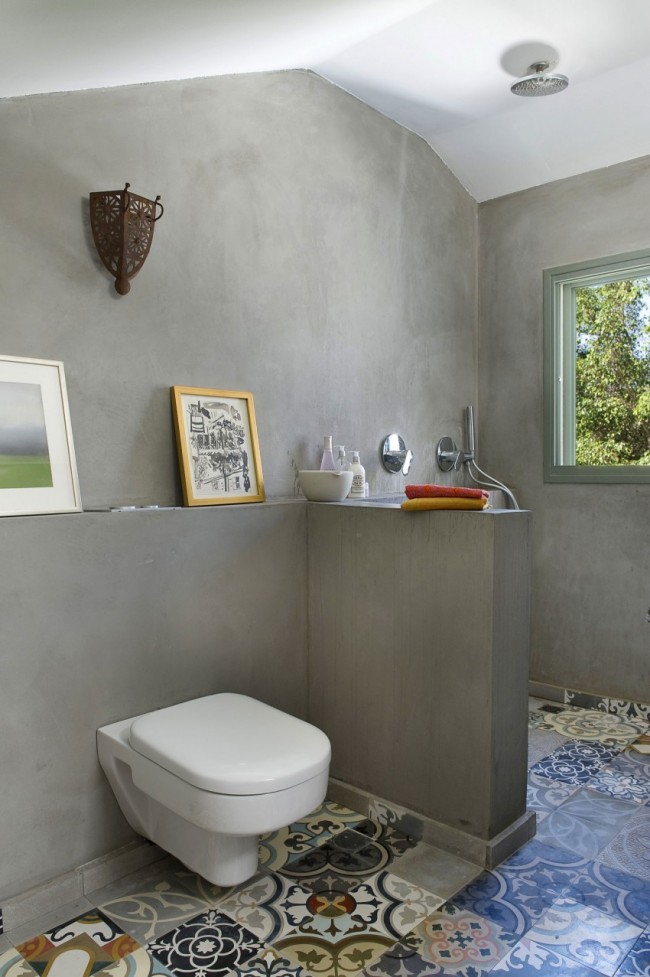 مزيج عضوي من بلاط الزينة على الأرض مع الجدران الخرسانية في حمام مشترك لمنزل خاص