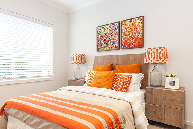 يتم التأكيد بشكل عضوي على المزاج المشرق والمشمس لغرفة النوم من خلال درجات ألوان الخوخ والتراكوتا والبرتقالي.