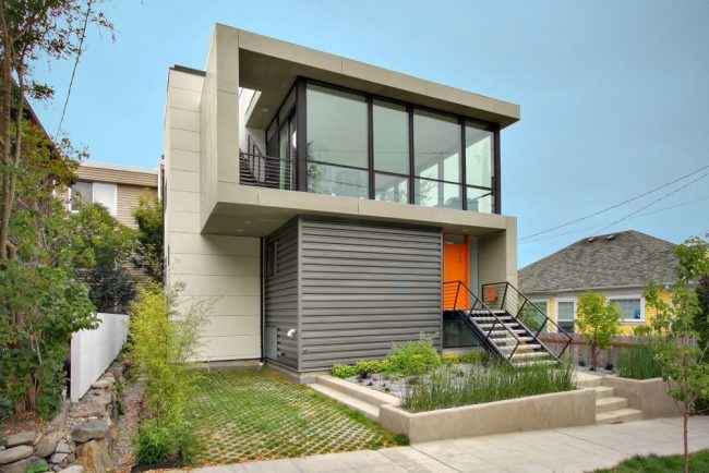 Стилен частен дом с млечно сив балкон с ярко оранжева врата
