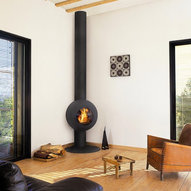 Ein runder Kamin verleiht dem Wohnzimmer trotz des allgemeinen Konzepts von Country und Loft einen Hauch von Futurismus