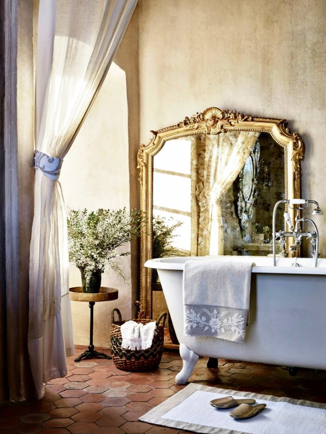 Styl Provence v interiéru. Okouzlující kombinace: terakotová dlažba, dekorativní omítka, plátěný závěs a litinová vana s ozdobnými nohami