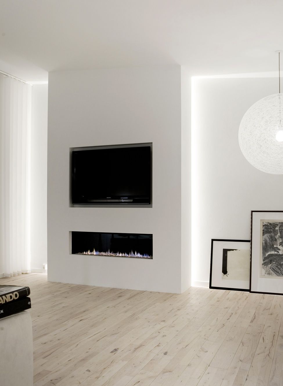 Televizní monitor a krb zapuštěné do výklenků - elegantní minimalistický trik