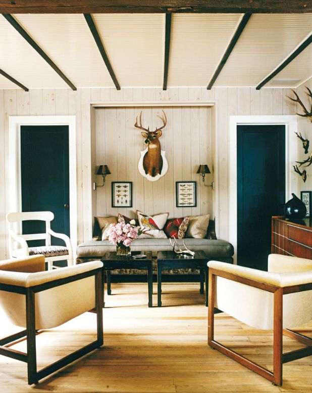Interieur im skandinavischen Stil: dunkle Türen, Stühle, Couchtische und Dosen an der Decke, kombiniert mit heller Wandverkleidung und Textilien