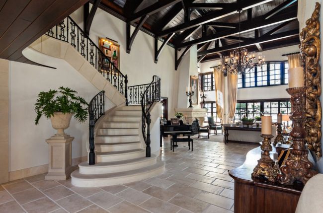 Das klassische Interieur eines luxuriösen Landhauses. Dunkle Holzdecke, weiße Wände, Marmorstufen und geschnitzte Elemente im Dekor