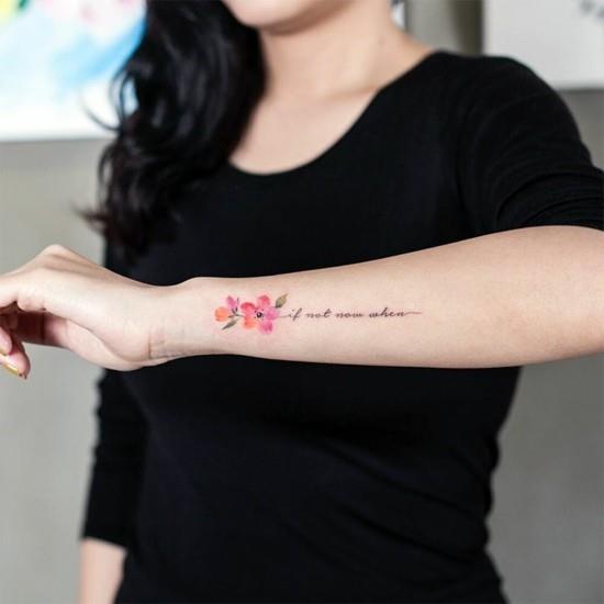 tatuaż kwiat wiśni na przedramieniu z napisem