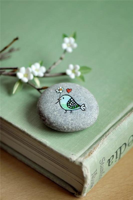 malowanie ptaka z kwiatem i sercem na kamieniu