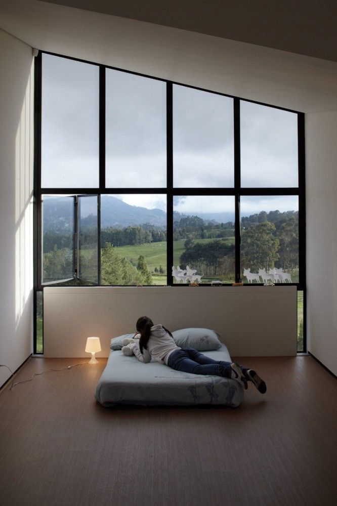 Schlafzimmer eines Hauses mit Buntglasfassade mit Blick auf die Berge