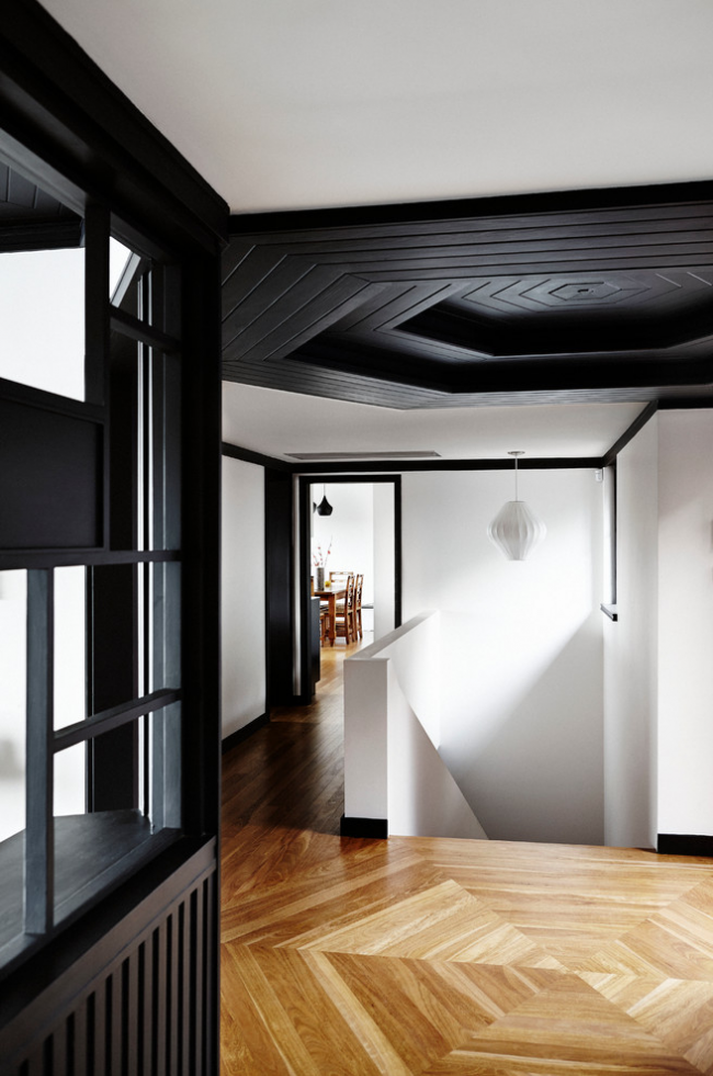 Stilvoll kontrastierendes Interieur des Flurs mit lackierter Holzimitation an der Decke