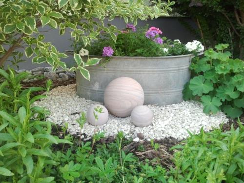 Conception de jardin avant avec sphère en bois de cailloux de pot de fleur de gravier
