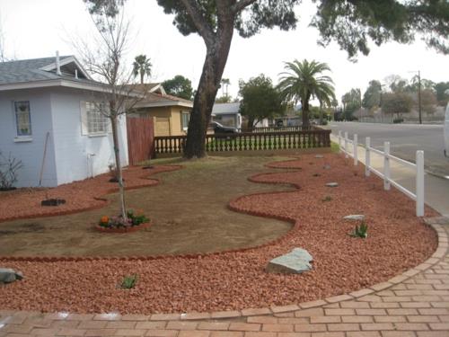 Conception de jardin avant avec des formes arquées de galets pierres naturelles