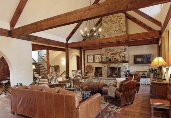 salon skórzana sofa kominek fajne pomysły na umeblowanie drewniane belki kamienne w stylu wiejskim