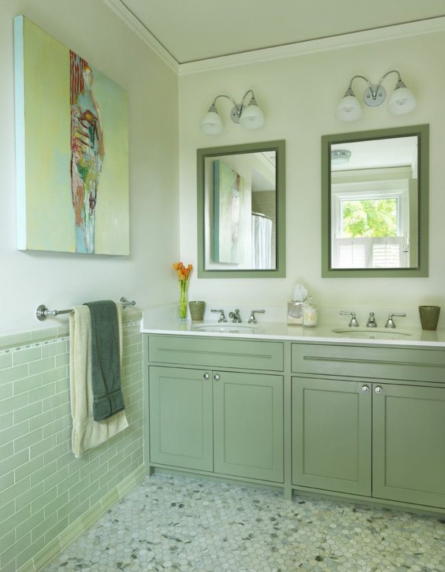 Koupelna vyzdobená v různých odstínech máty. Abstraktní obraz na zdi s jemným žlutým pozadím dodává interiéru teplo