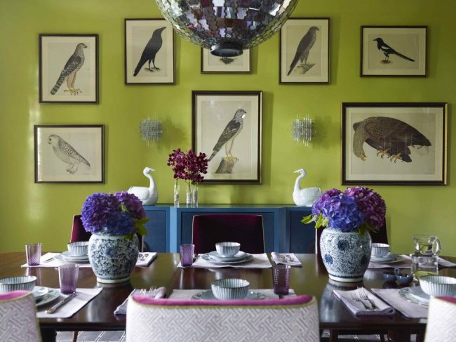 Současná jídelna se zářivými světle zelenými tapetami, grafikou ptáků na středové stěně a akvamarínovou konzolí