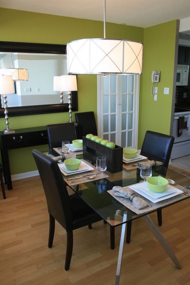 Jablečné zelené stěny v kombinaci s lakonickým černým nábytkem vytvářejí stylový interiér v minimalistickém stylu.