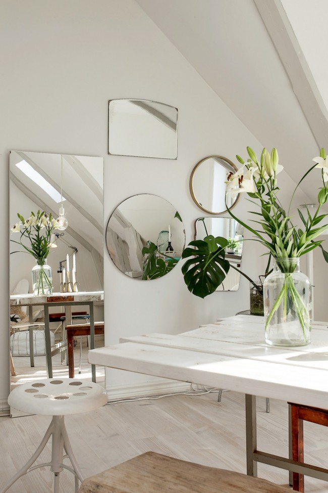 Белите стени могат да бъдат декорирани с огледала с различни форми и размери, полученият „ред прозорци“ оживява стаята и я прави много по -ярка
