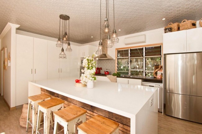 Dřevěné žaluzie v kuchyni v teplých světlých barvách udržují útulnou atmosféru místnosti